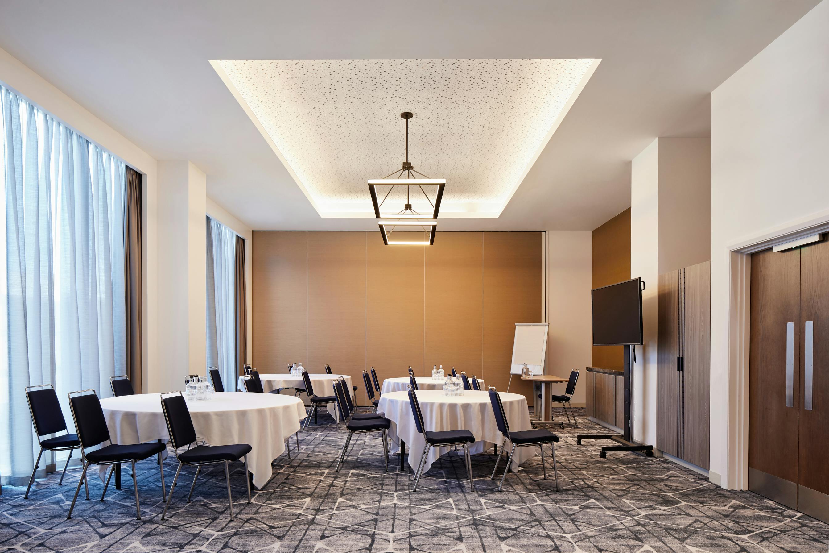 Hyatt Regency Manchester meeting room with round tables, ideal for workshops and presentations.