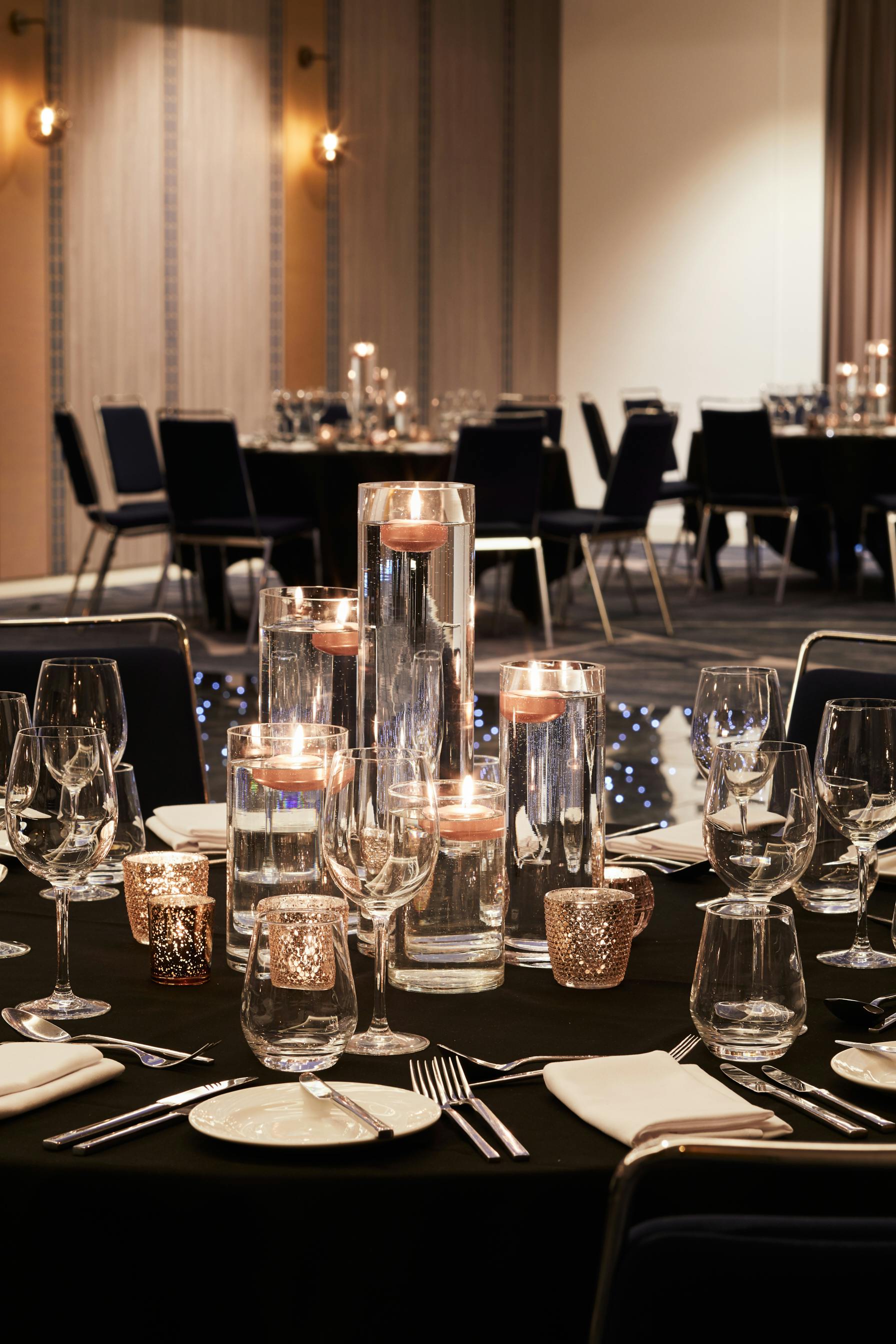 Elegant dining table with glass centerpieces in The Waterhouse Room, Hyatt Regency Manchester.