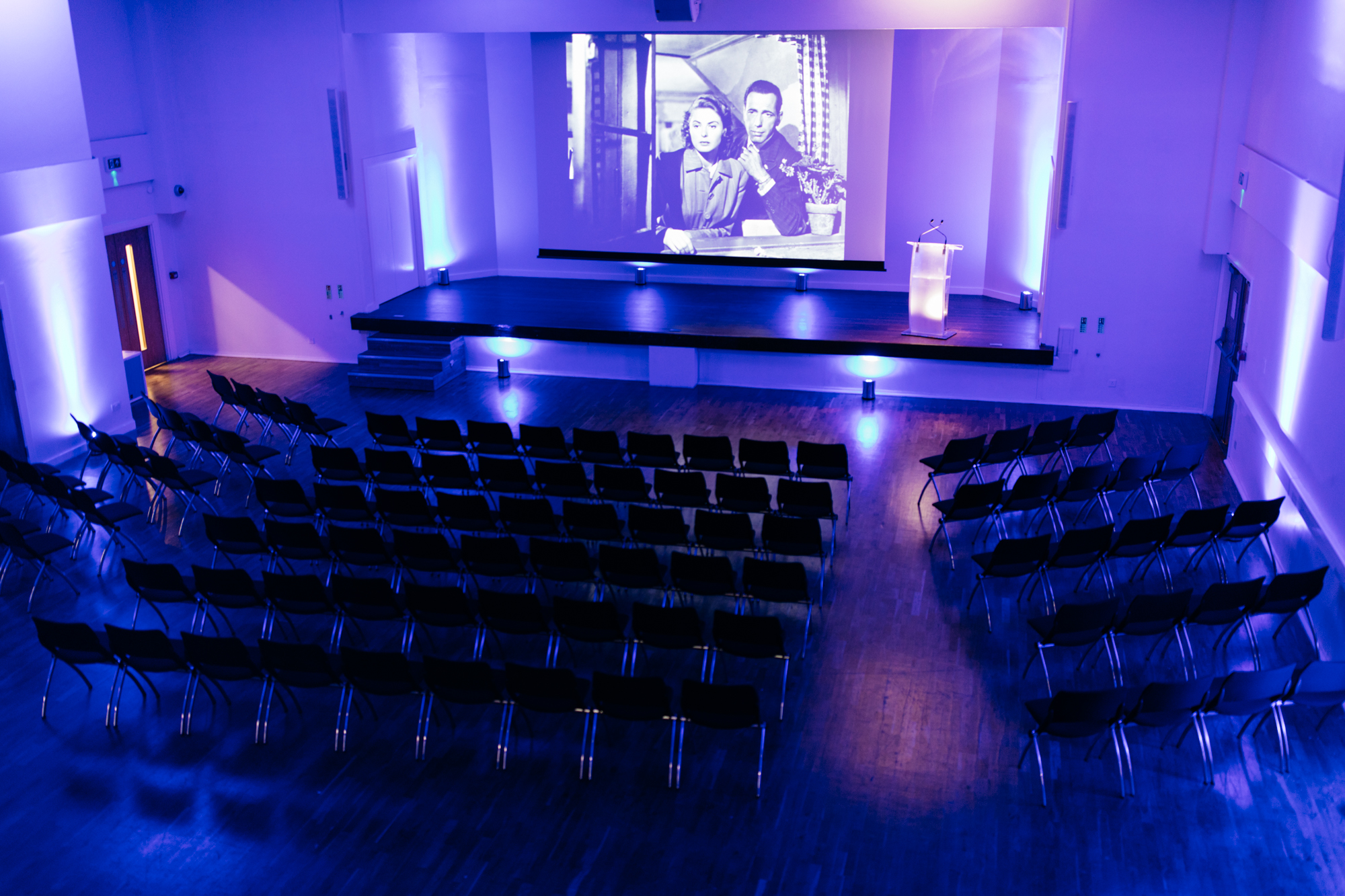 Main Hall in Queens Gate House with purple lighting, ideal for conferences and seminars. - Banner