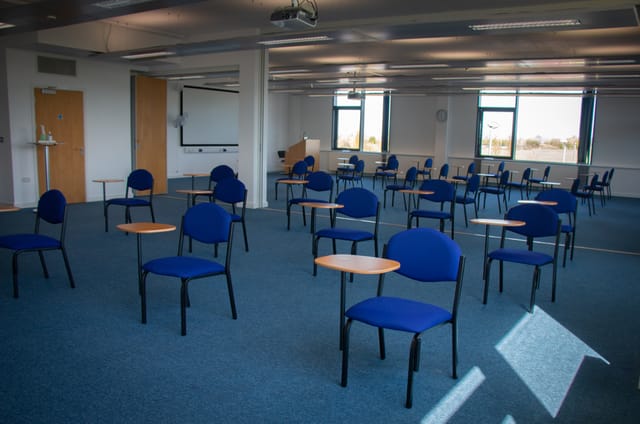 Spacious meeting room with chairs and tables for workshops at Future Skills Centre.