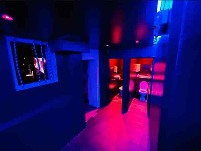 Dimly lit corridor with blue and purple lighting at Bonkers Bar for events.