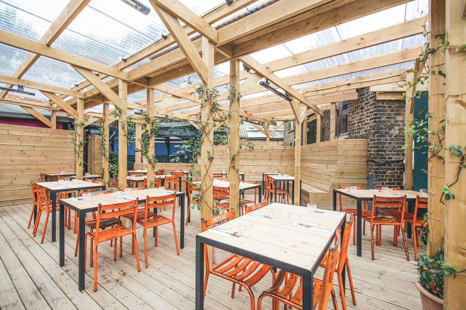Outdoor event space in Mike's Peckham with wooden structure, ideal for summer gatherings.