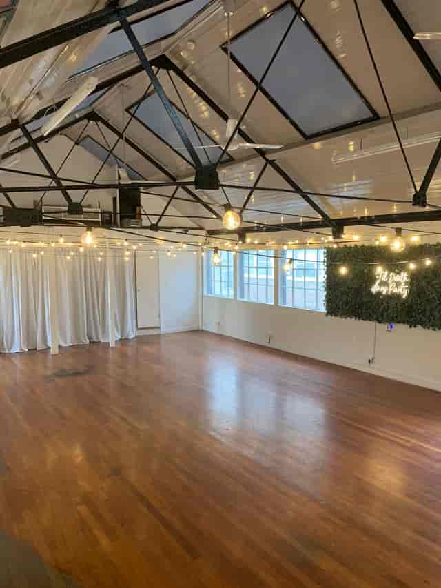 Industrial-chic event venue with green wall, perfect for social gatherings and corporate mixers.