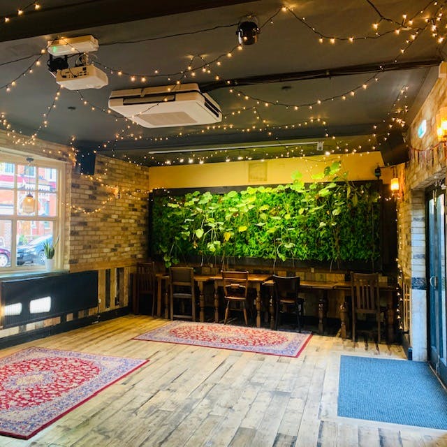 Charming Function Room with lush green wall for intimate gatherings and workshops.