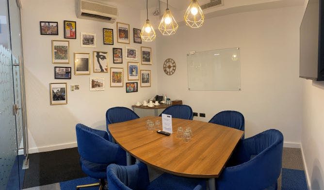 Meeting room at Rylands, featuring a round table and blue chairs for collaborative sessions.