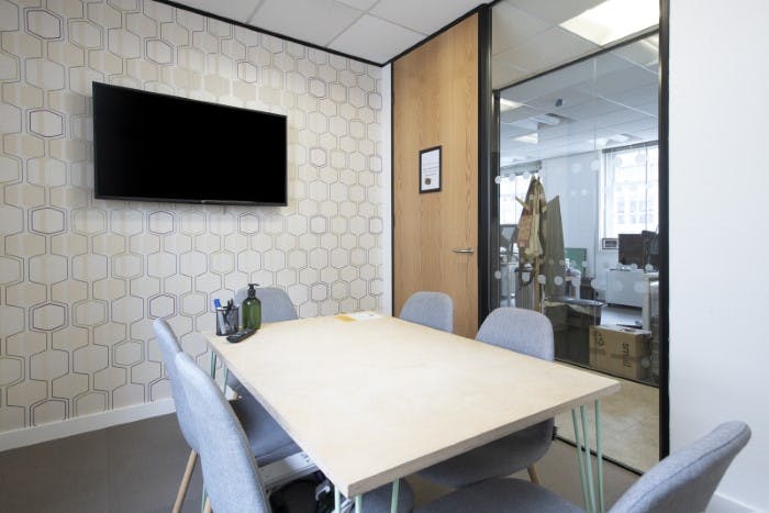 Modern meeting room at Yeager, featuring sleek table and wall-mounted TV for presentations.