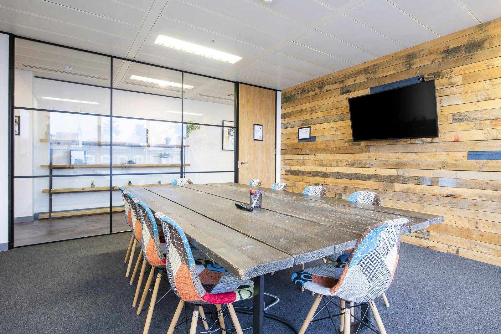 Modern meeting room with large wooden table, ideal for collaborative brainstorming sessions.