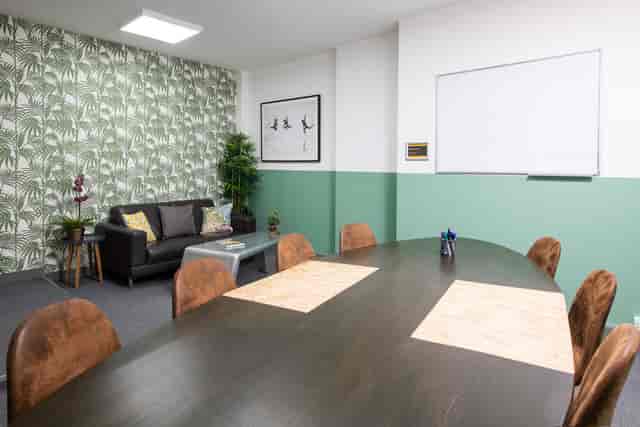 "Meeting room in Runway East Soho with round table, greenery for creative collaboration."