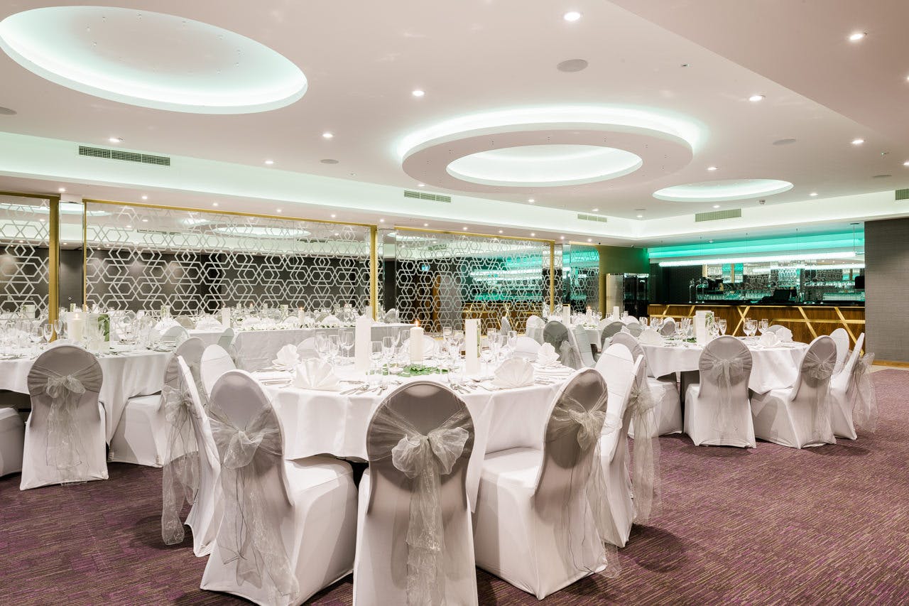 Elegant event space at The Raeburn, set for formal gatherings with round tables and soft lighting.