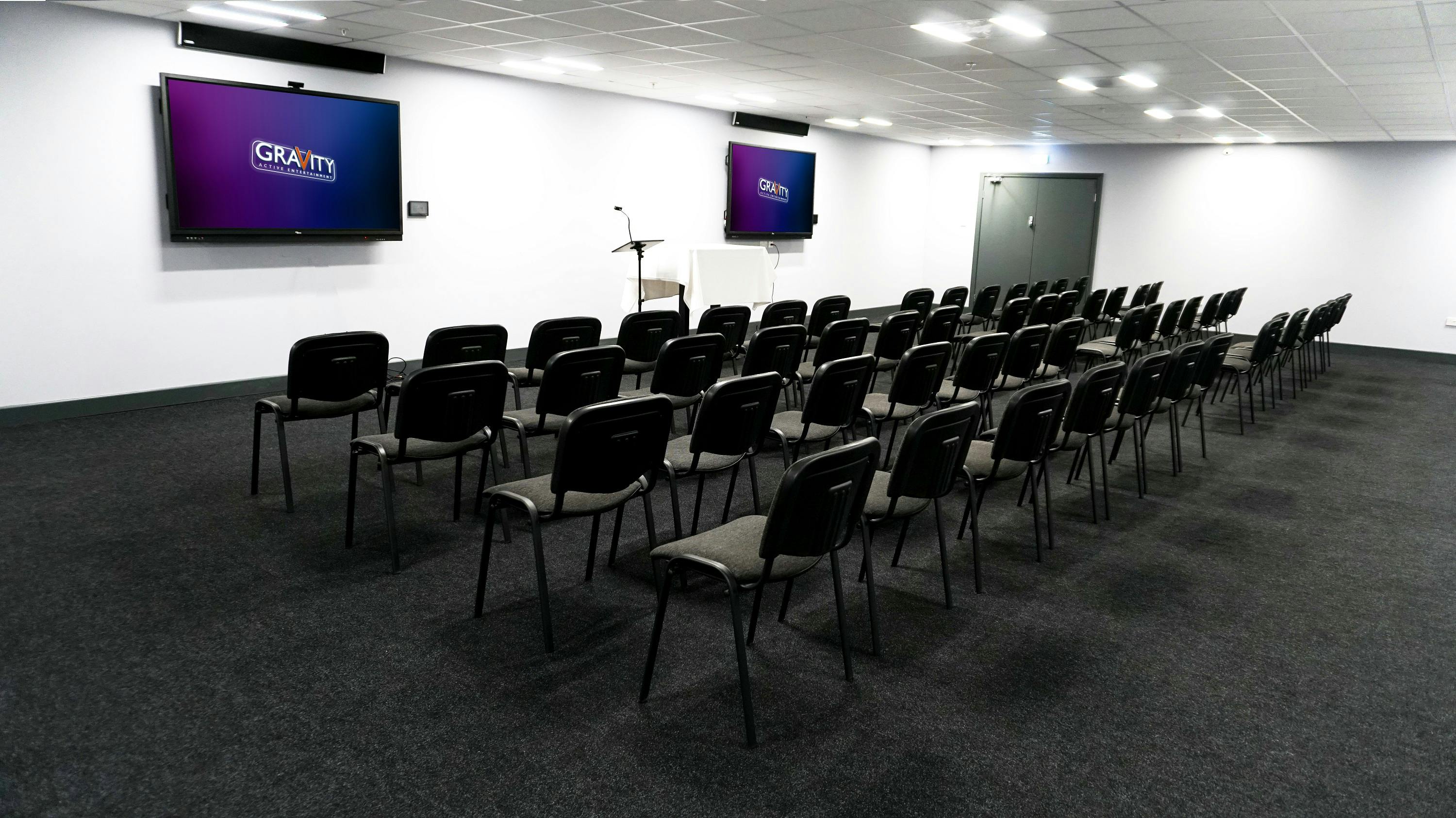 Isaac Newton Suite at Gravity MAX: modern meeting space with large screens for workshops.