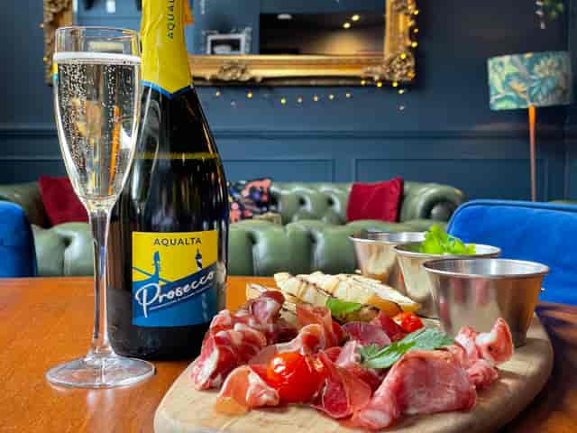 Elegant lounge setup with prosecco and charcuterie for networking events.