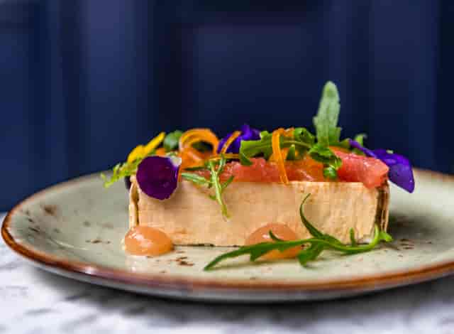 Elegant gourmet dish with vibrant edible flowers for upscale events catering.