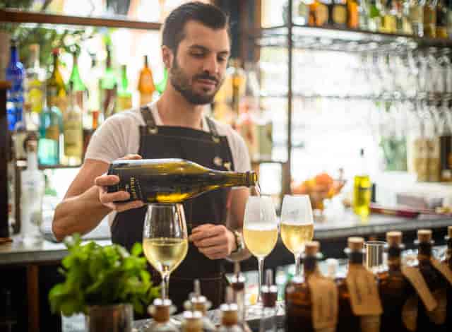 Bartender pouring champagne in elegant flutes at The Cavendish Lounge for events.