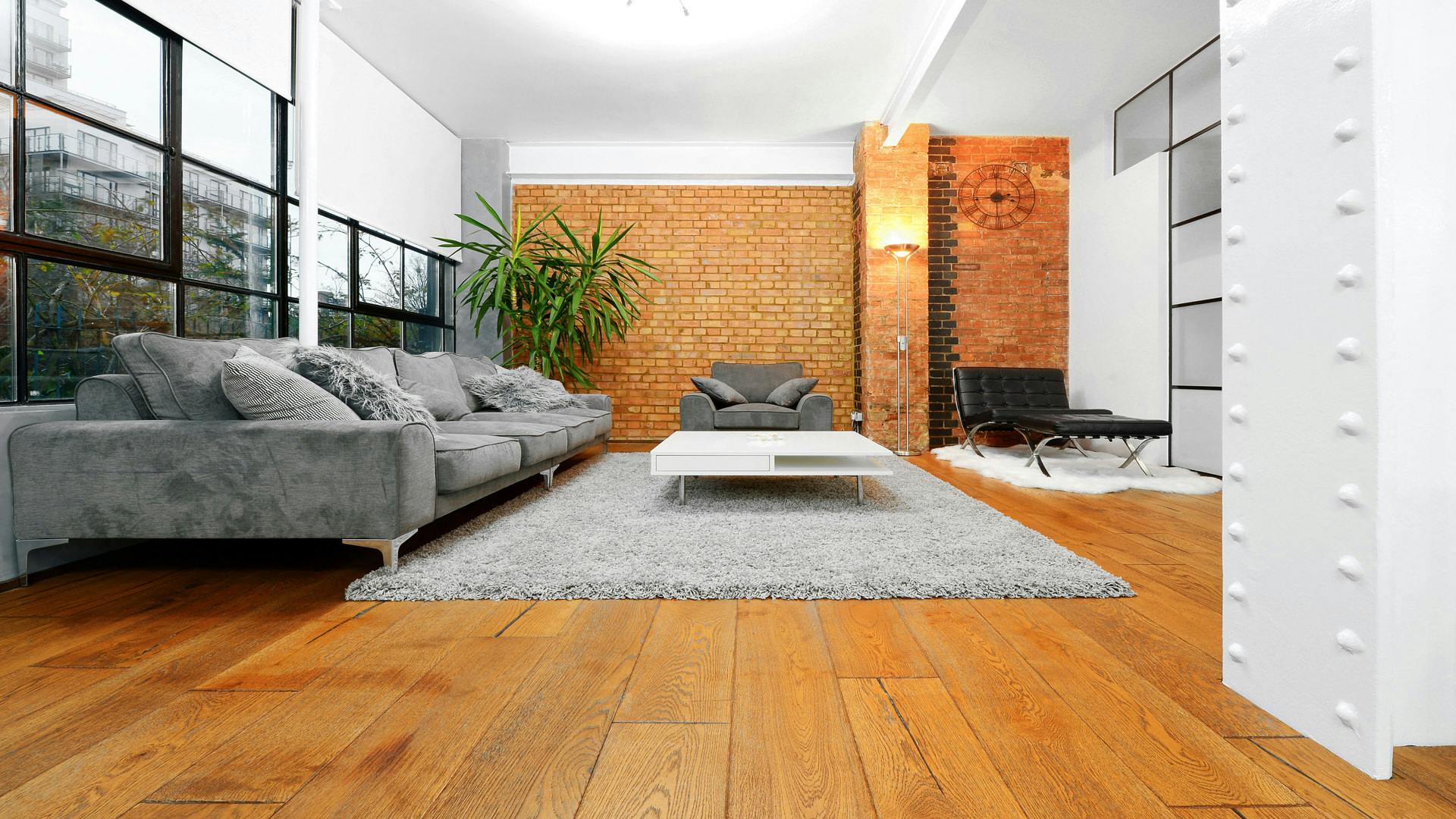 Modern meeting space with gray sofas and natural light for informal gatherings.