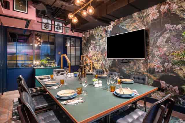 Stylish meeting space at Yotel Manchester with vibrant floral wallpaper for events.