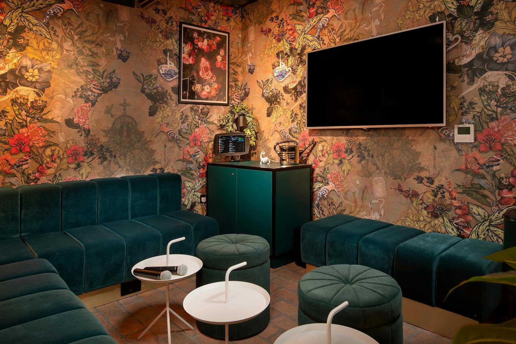 Stylish meeting space at Yotel Manchester with plush seating and vibrant floral wallpaper.