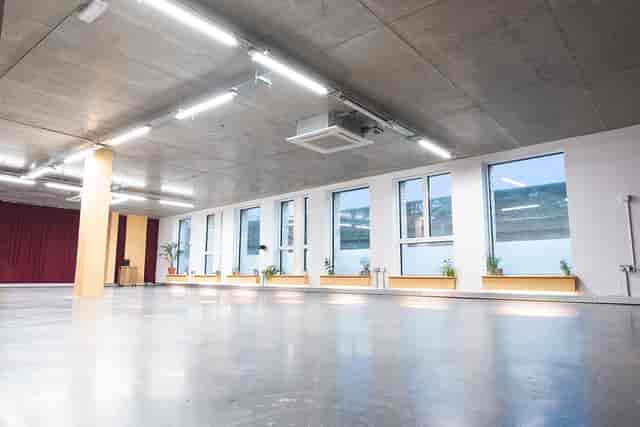 Versatile event space with natural light, ideal for workshops and corporate meetings.