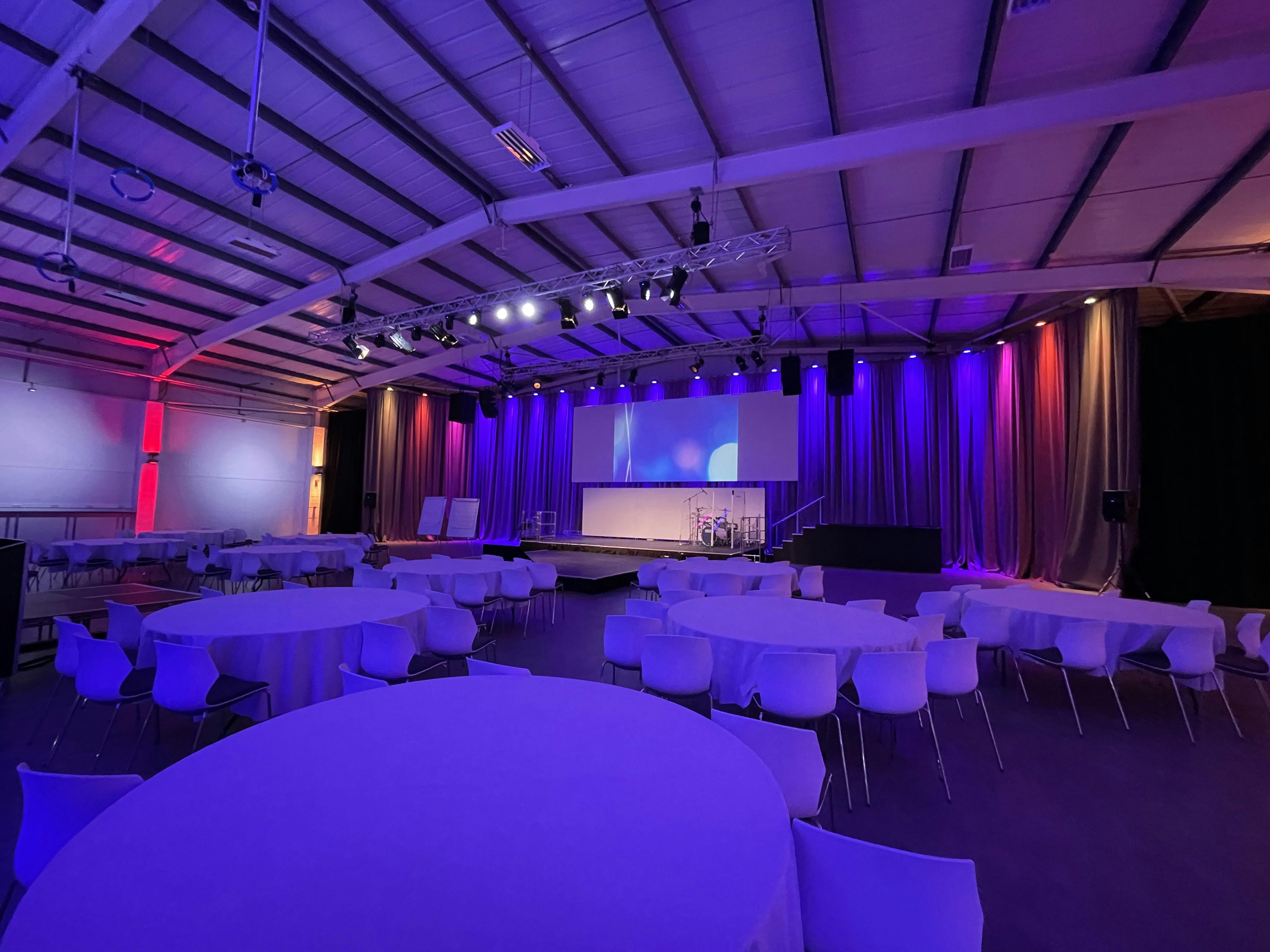Versatile event space with vibrant lighting for dynamic meetings and corporate events.