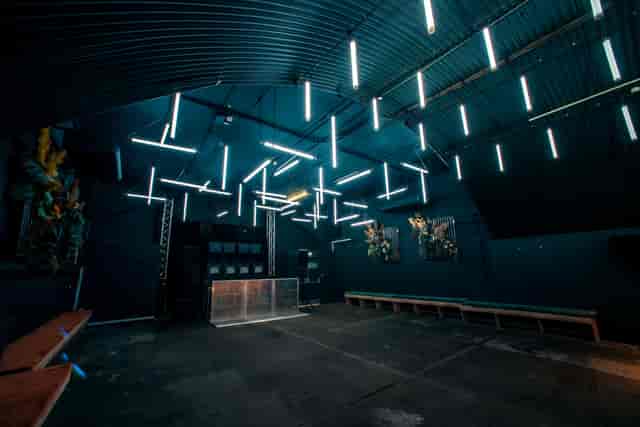 Modern industrial event space with linear lighting for gatherings and celebrations.