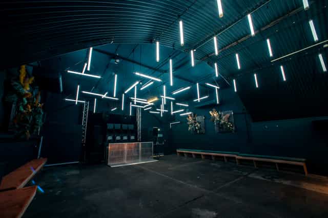 Modern industrial event space with linear lighting for gatherings and celebrations.