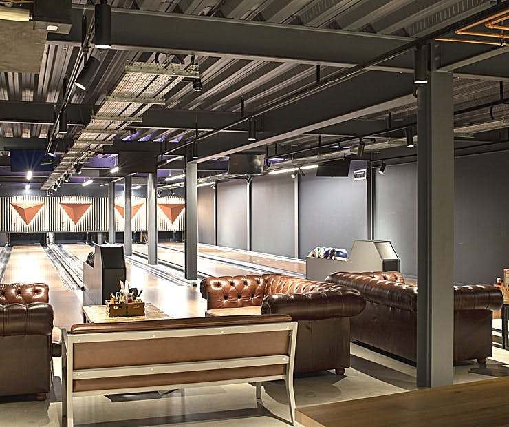 Stylish bowling alley with leather seating for corporate events and social mixers.