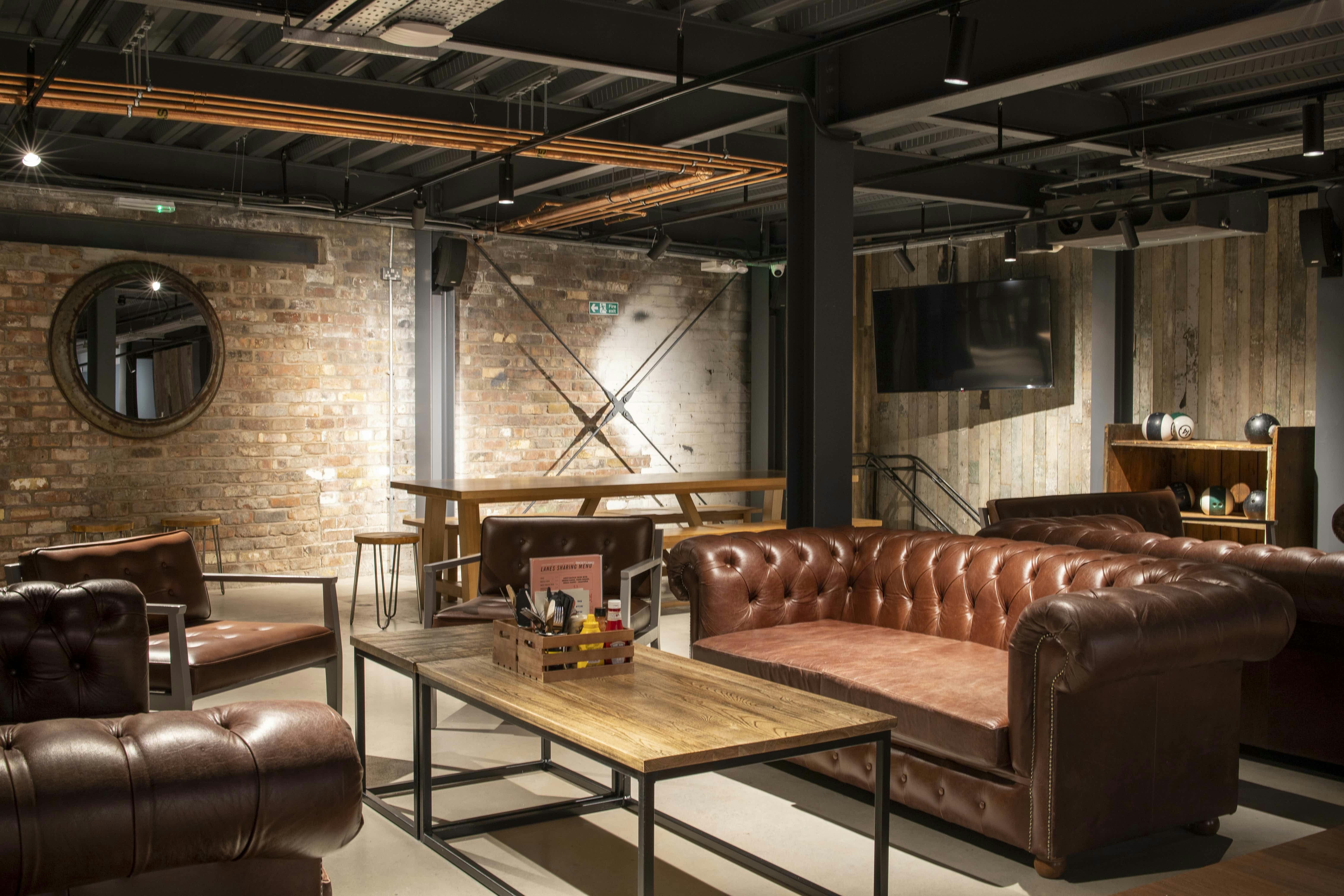 Stylish lounge with leather sofas for networking events at PINS Social Club.