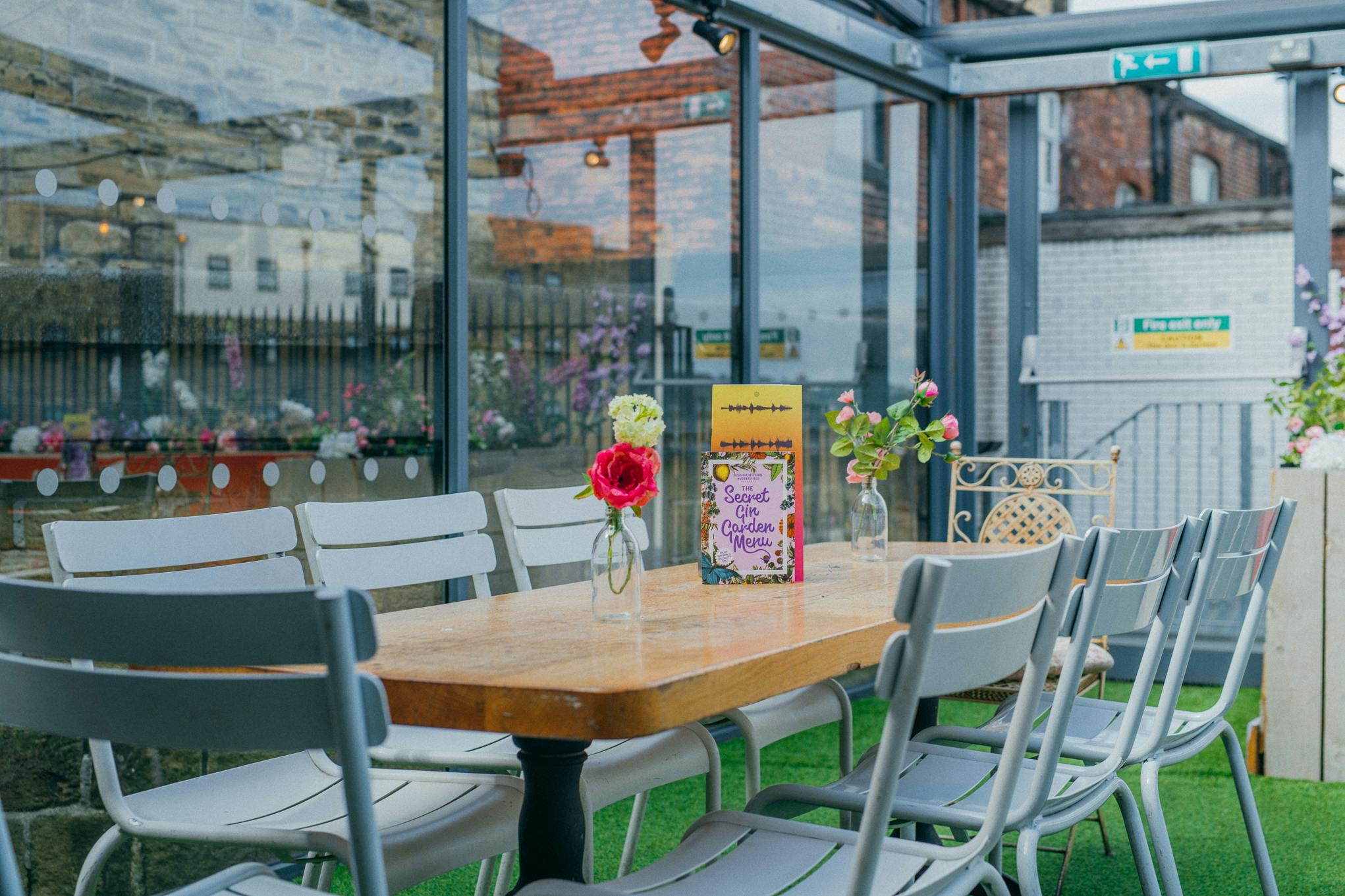 Whole Venue Hire in Revolution Huddersfield, bright meeting space with wooden table, ideal for events.