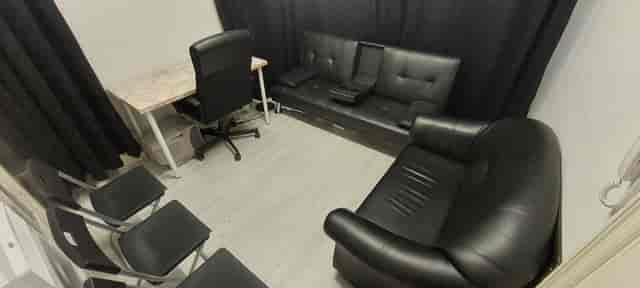 "BossLadyTV meeting space with black leather couch, ideal for brainstorming sessions."