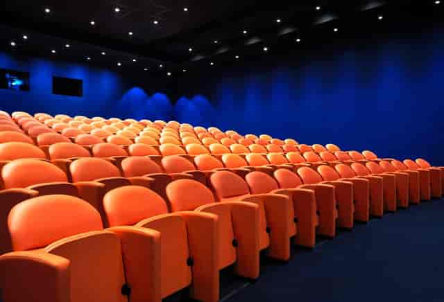 Modern auditorium with orange seating in The Whitby Hotel, ideal for presentations and screenings.