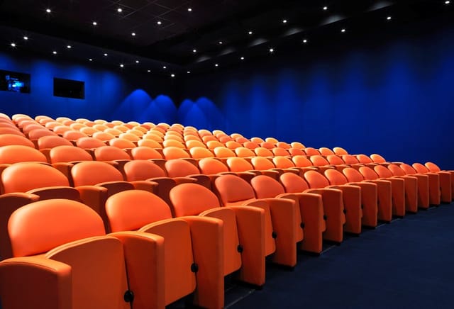 Modern auditorium with orange seating in The Whitby Hotel, ideal for presentations and screenings.