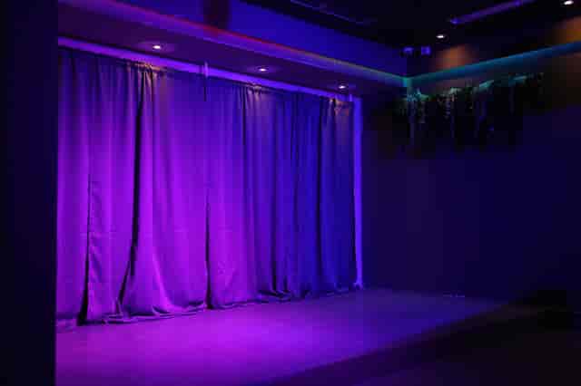 Stage setup with purple lighting in versatile event venue for presentations and performances.