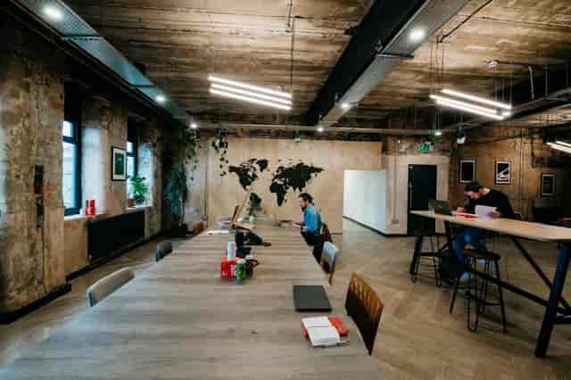 Modern meeting space at North Brewing Co with wooden table and world map mural.