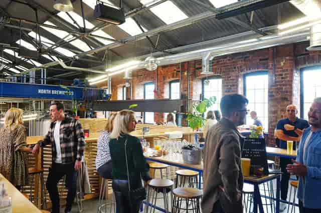 Vibrant networking event at North Brewing Co with industrial-chic decor and stylish bar.
