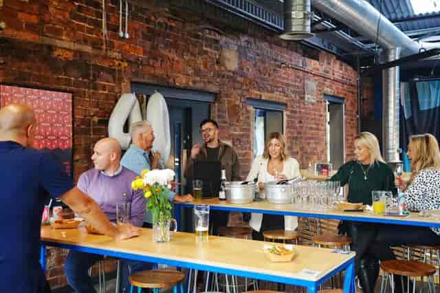 Networking event at North Brewing Co with attendees around a long table.