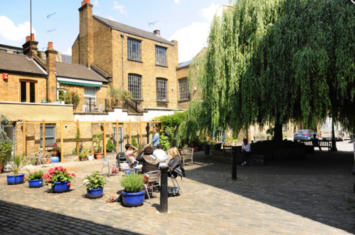 Charming outdoor venue with lush greenery for casual meetings and events.
