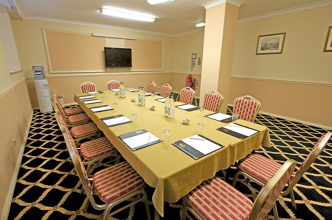 Piccadilly Suite at Britannia Hotel: elegant meeting room with long table and screen.