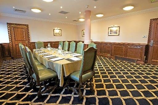 Elegant meeting room at Britannia Hotel Manchester with green chairs, ideal for corporate events.