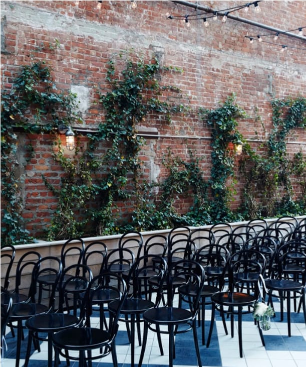 Main Hall & Garden Terrace at Wythe Hotel, rustic brick wall, intimate event venue.