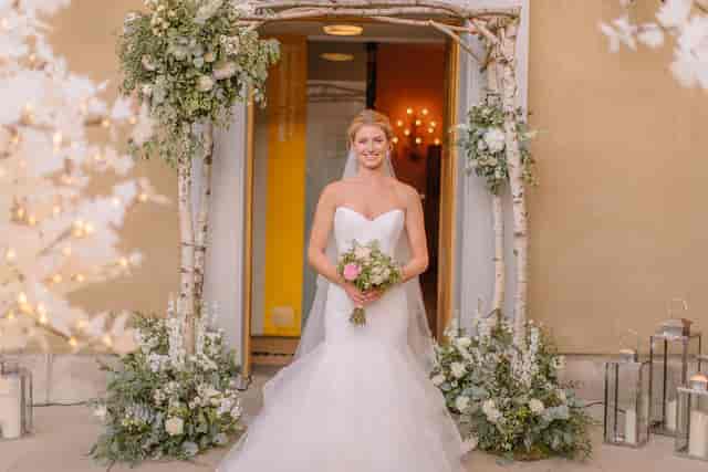 Elegant bride at wedding entrance in Banqueting House, showcasing romantic decor and ambiance.