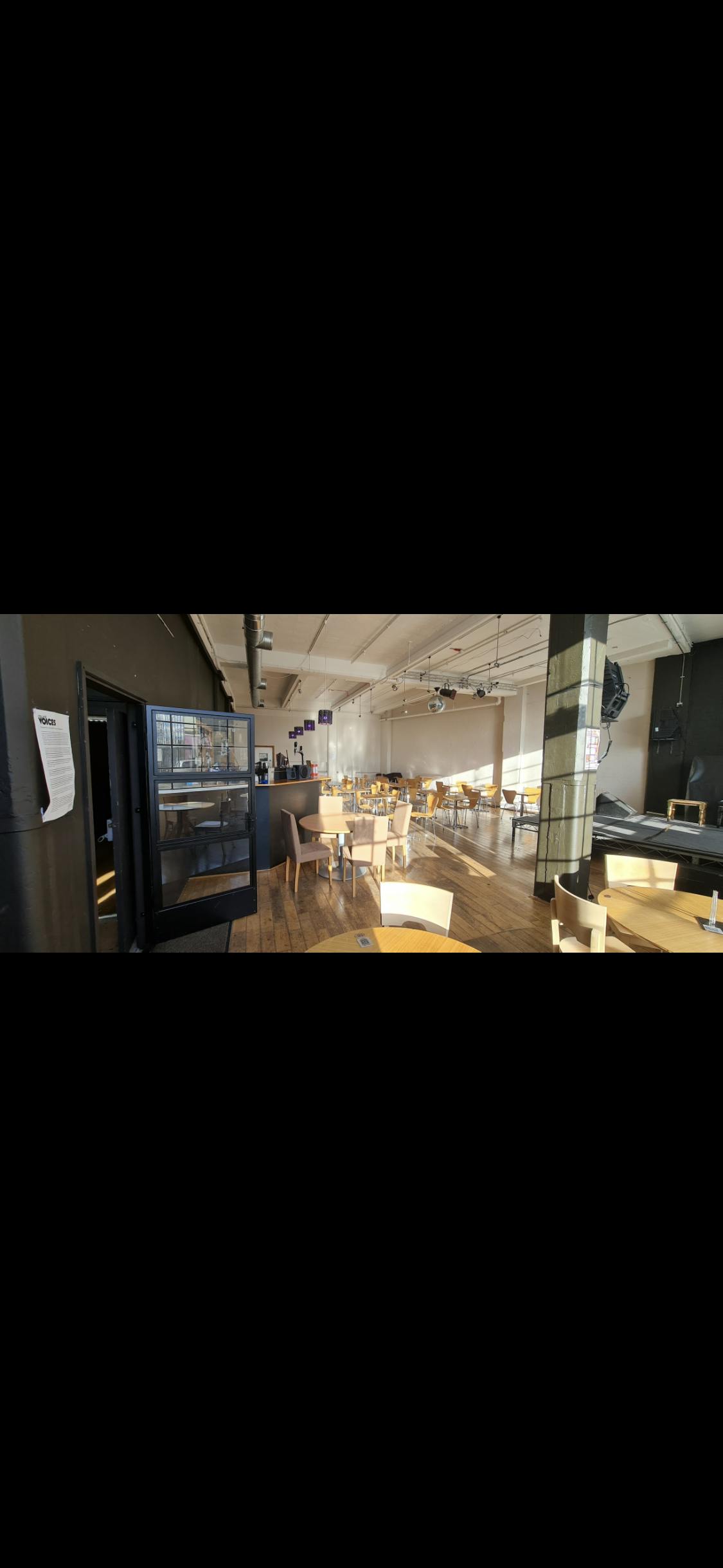 Versatile MAAD event space with natural light, ideal for gatherings and presentations.