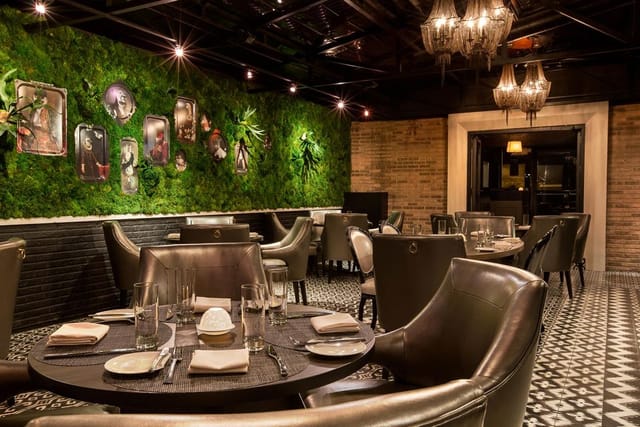 Sophisticated Terrace Room dining space with lush green wall for events and gatherings.