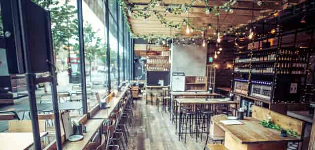 Royal box in Vagabond Victoria, modern venue with wooden tables for meetings and events.