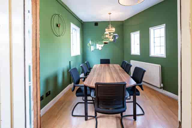 Modern meeting room with wooden table and black chairs in Conway Hall, perfect for collaboration.