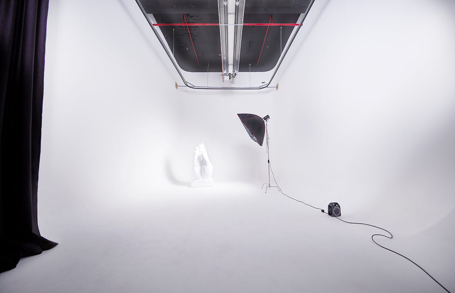 Minimalist studio space with white backdrop for creative events and photo shoots.