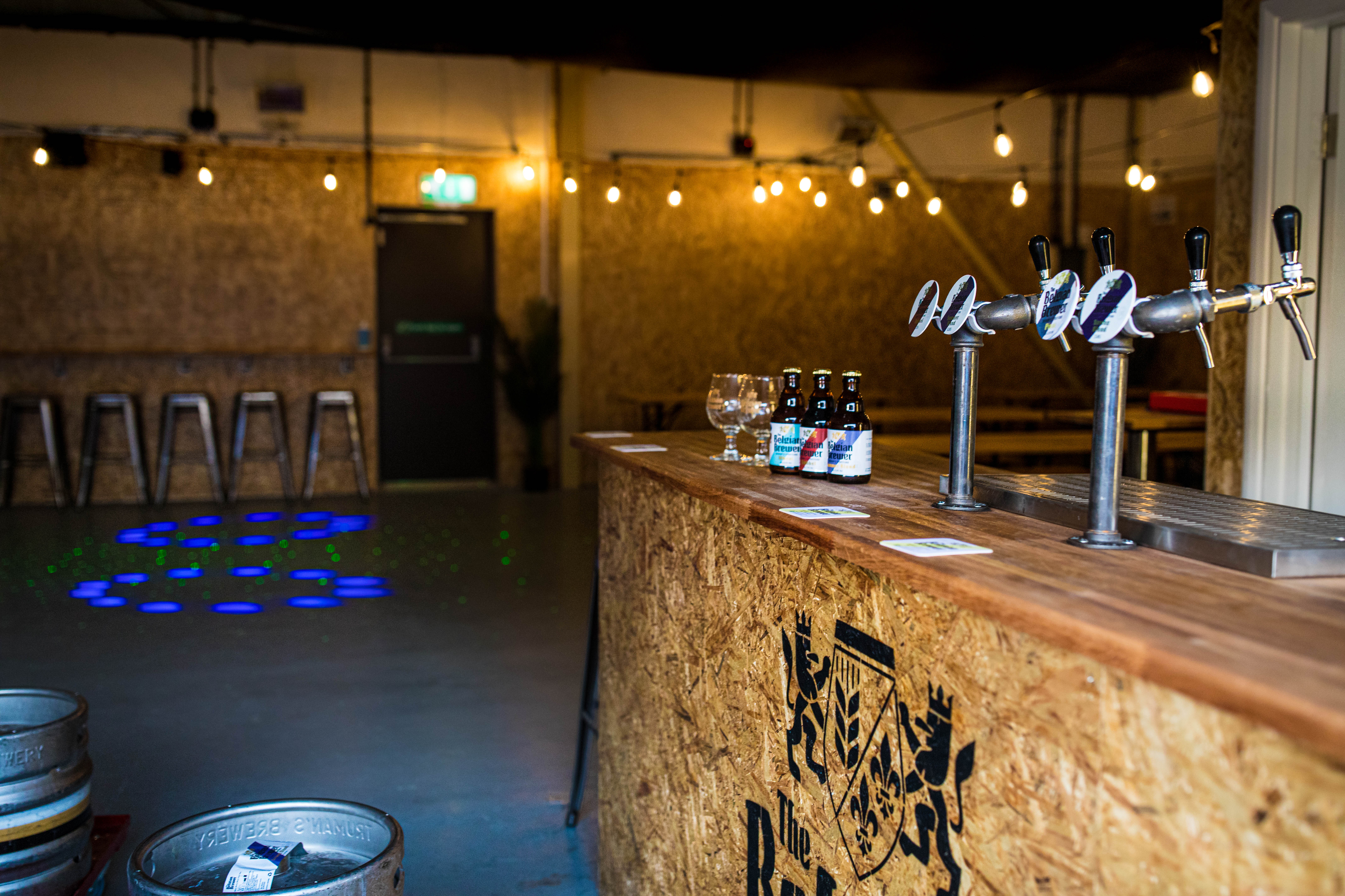 Stylish Belgian Brewer Event Hall with wooden bar, ideal for social gatherings and networking. - Banner