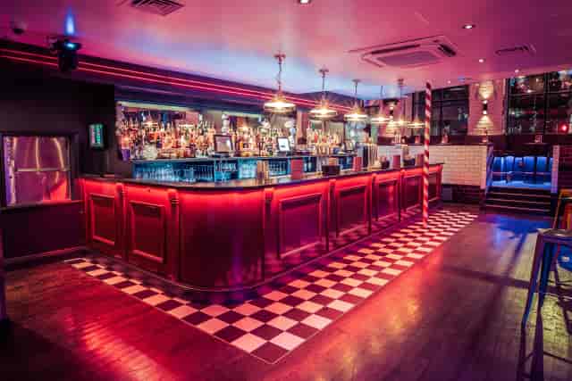Mezzanine bar with red LED lighting, ideal for cocktail receptions and vibrant after-party venues.