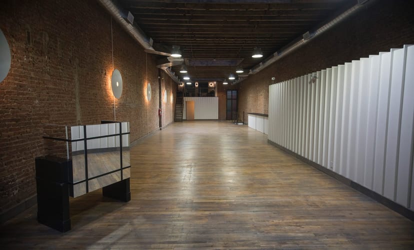 Spacious event space with exposed brick walls in The Flat NYC for meetings and gatherings.