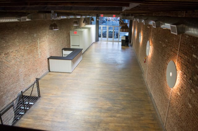 Spacious NYC event venue with exposed brick, perfect for meetings and gatherings.