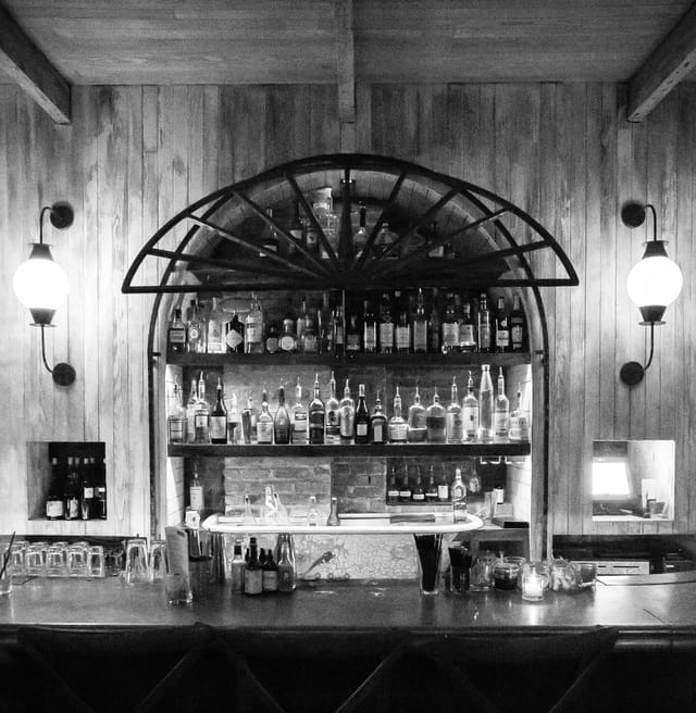Elegant rustic bar with arch and ambient lighting, ideal for networking events.