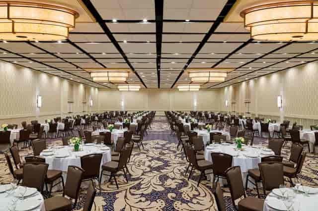 Spacious Delta by Marriott banquet hall with elegant round tables for weddings and conferences.